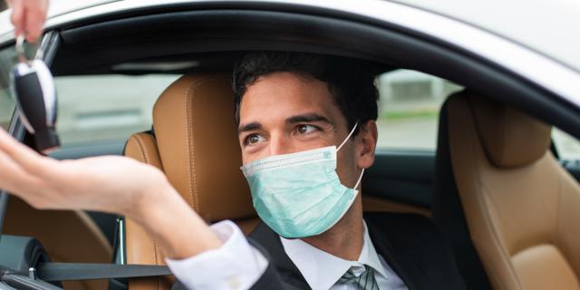 man in mask in car